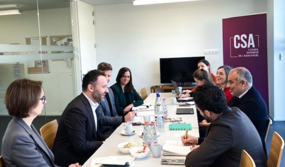 © DR Photo couleur. Un groupe de femmes et d'hommes autour d'une table de réunion, en Belgique à Bruxelles